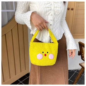 Close-up of yellow plush mini shoulder bag with cute cartoon chick face design