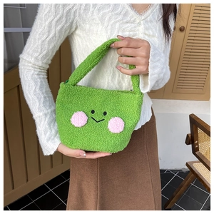 Detail of green fuzzy plush tote bag with cute cartoon smiling face and soft handles
