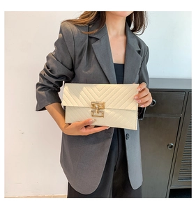 Detail der cremefarbenen Briefumschlag-Clutch mit V-Steppung und goldenem Metallschloss