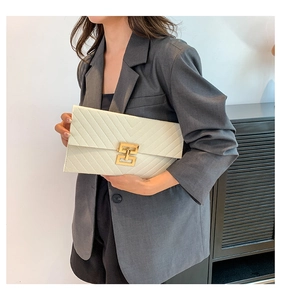 Detail der weißen Briefumschlag-Clutch mit V-Steppung und goldener Metallschnalle