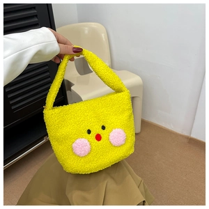 Close-up of fluffy bright yellow plush shoulder bag with cute cartoon bear face design
