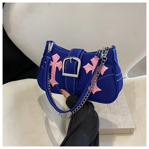 Detail of navy canvas underarm bag with pink cross embroidery and large silver buckle