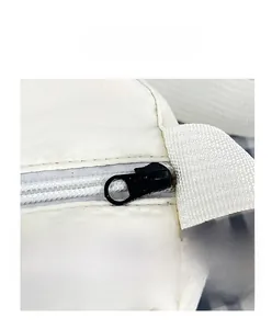 Detailed close-up of durable metal zipper and refined stitching on white nylon bag