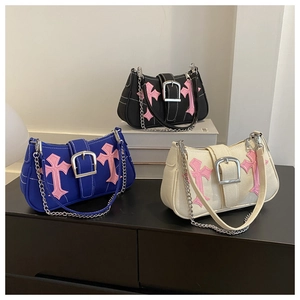 Detailed shot of three minimalist underarm bags featuring gothic pink cross patches