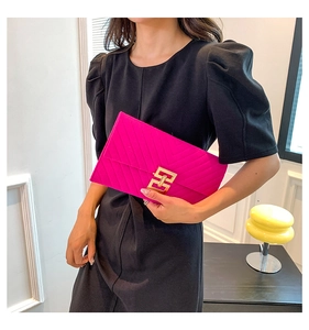 Detail der fuchsiafarbenen Briefumschlag-Clutch mit V-Prägung und goldener Schnalle