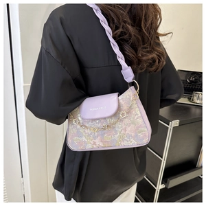 Détail du sac floral violet avec bandoulière tissée et chaîne décorative fleur de prunier dorée