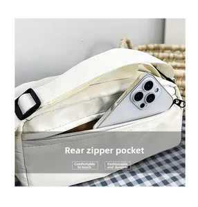 Detail of white nylon shoulder bag with a functional back zipper pocket for phone storage