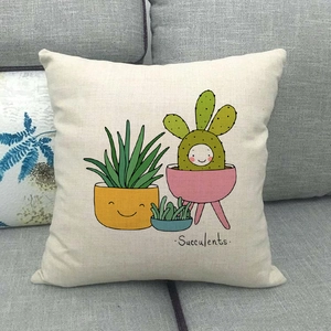 Close-up of linen cushion cover featuring succulent plants on a grey fabric sofa