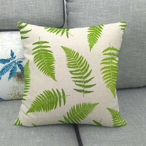 Leinen-Kissenbezug mit grünen Tropenblatt-Prints auf modernem grauem Stoffsofa