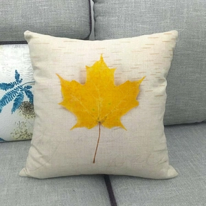Close-up of linen pillowcase with yellow maple leaf pattern and Enjoy your life text