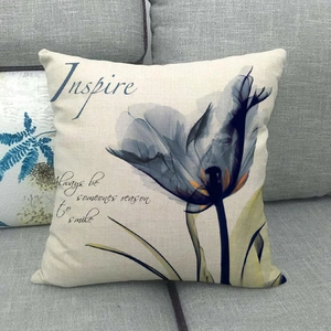 Close-up of linen cushion cover with purple floral print and inspiring text on a sofa
