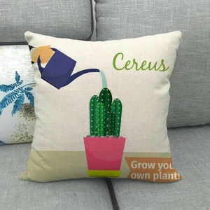 Linen cushion cover with cactus design and text on a grey fabric sofa at home