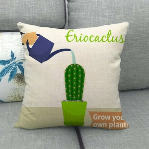 Close-up of linen cactus pillowcase with watering can print on a grey fabric sofa