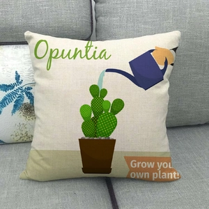 Close-up of linen pillow cover with cactus print and watering can on a gray sofa