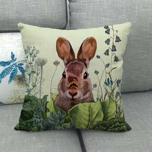 Macro shot of linen Easter bunny pillow case with vintage floral pattern on grey sofa