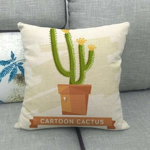 Detail of cartoon cactus print on linen pillowcase against a gray fabric sofa