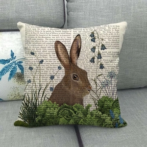 Close-up of linen pillowcase with vintage rabbit print on a gray sofa fabric