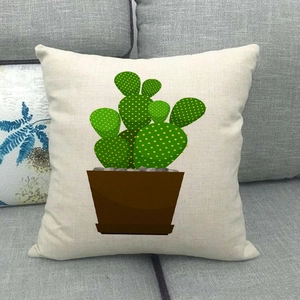 Detail of linen pillow cover with green cactus print on a grey fabric sofa background