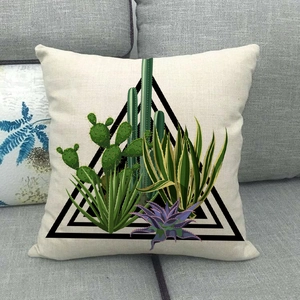 Close-up of linen pillow cover with cactus print on a grey fabric sofa