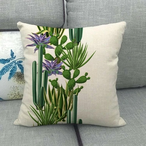 Detailed close-up of cactus pattern on linen pillowcase placed on a gray sofa