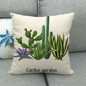Detail of linen cushion cover showing printed cactus garden design on a grey sofa