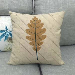 Detail of linen pillowcase with oak leaf print and wood grain texture on sofa