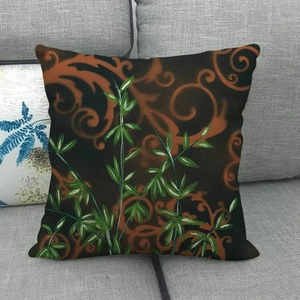Detailansicht eines Leinenkissenbezugs mit orangefarbenen Ranken auf grauem Sofa