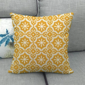 Linen decorative throw pillow cover with yellow geometric patterns on a grey sofa