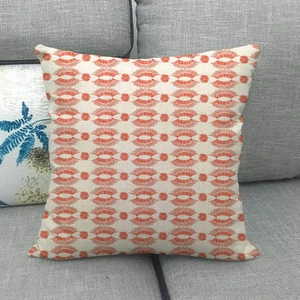 Detail of geometric fan pattern on a beige linen decorative pillow on a grey sofa