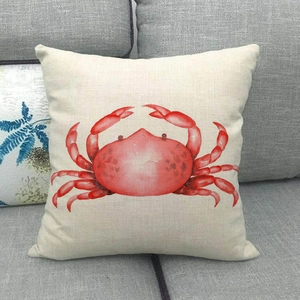 Détail de l'imprimé crabe rouge sur une housse de coussin en lin sur canapé gris
