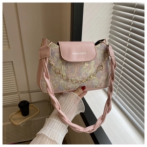 Detail der floralen Handtasche mit rosa Lederklappe und goldener Blumenkette