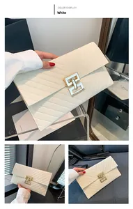 Nahaufnahme der weißen gesteppten Briefumschlag-Clutch mit goldenem Metallschloss und Muster
