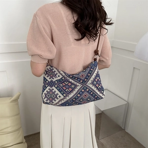 Ethnic style canvas tote bag with geometric patterns and brown leather strap on model