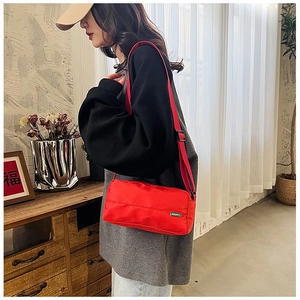 Detail of red nylon pillow crossbody bag with adjustable strap and EIMY brand tag