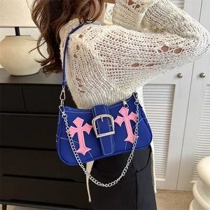 Blue canvas underarm bag with pink leather crosses and silver chain on model