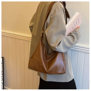 Detail of a dark brown leather hobo bag showing its smooth texture and elegant slouchy design