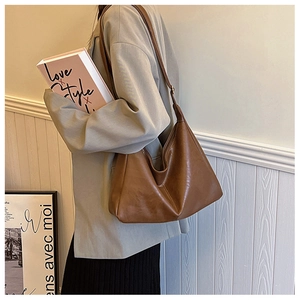 Brown pleated leather hobo bag styled with a grey blazer for a chic commuting look
