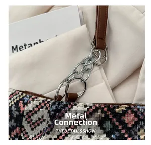Detail showing woven geometric fabric with brown leather strap and silver metal rings