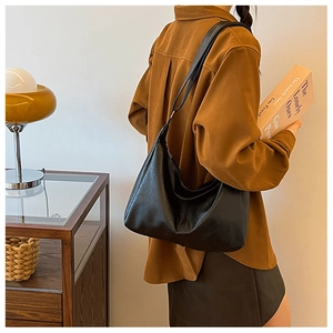 Detail of soft black matte faux leather hobo bag with elegant integrated shoulder strap