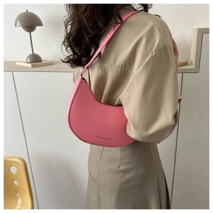 Detailed view of pink leather crescent underarm bag with gold hardware and logo