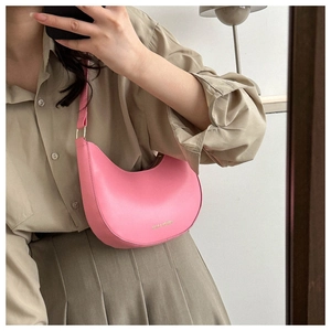 Detail of pink half-moon hobo bag with gold logo and smooth leather texture