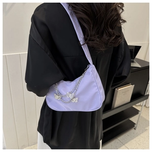 Détail du sac hobo lavande avec chaînes papillon argentées et bandoulière en tissu