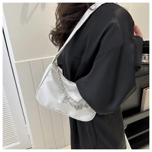 Sac bandoulière blanc en tissu avec chaîne papillon argentée porté à l'épaule