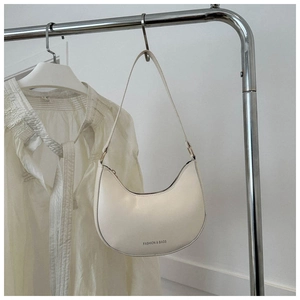Detail of off-white crescent underarm bag with gold metal rings on a silver rack