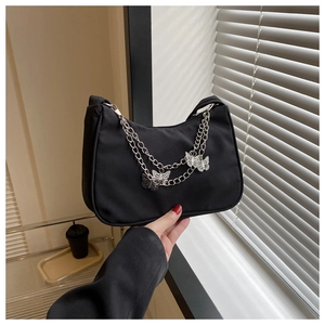 Détail du sac hobo en nylon noir avec doubles chaînes argentées et pendentifs papillon