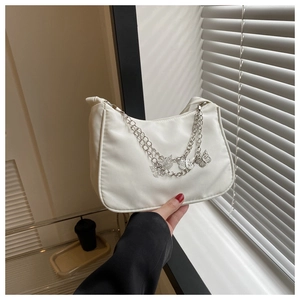 Détail du sac hobo en nylon blanc orné de chaînes décoratives à pendentifs papillon