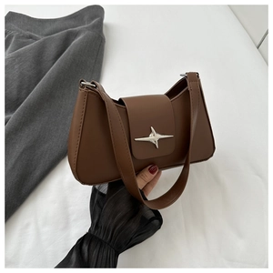 Détail du sac à bandoulière en similicuir marron avec boucle métallique en étoile argentée