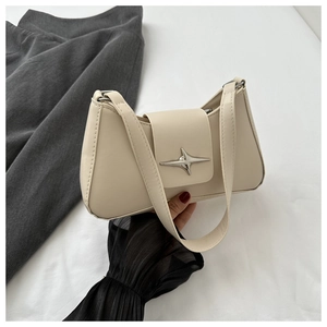 Détail du sac bandoulière en cuir crème avec boucle étoile argentée et surpiqûres