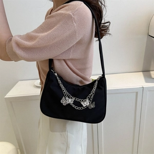Sac sous le bras croissant noir chic avec chaînes argentées et breloques papillon