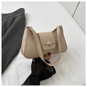 Détail du sac hobo beige avec une élégante boucle en forme d'étoile argentée à quatre branches
